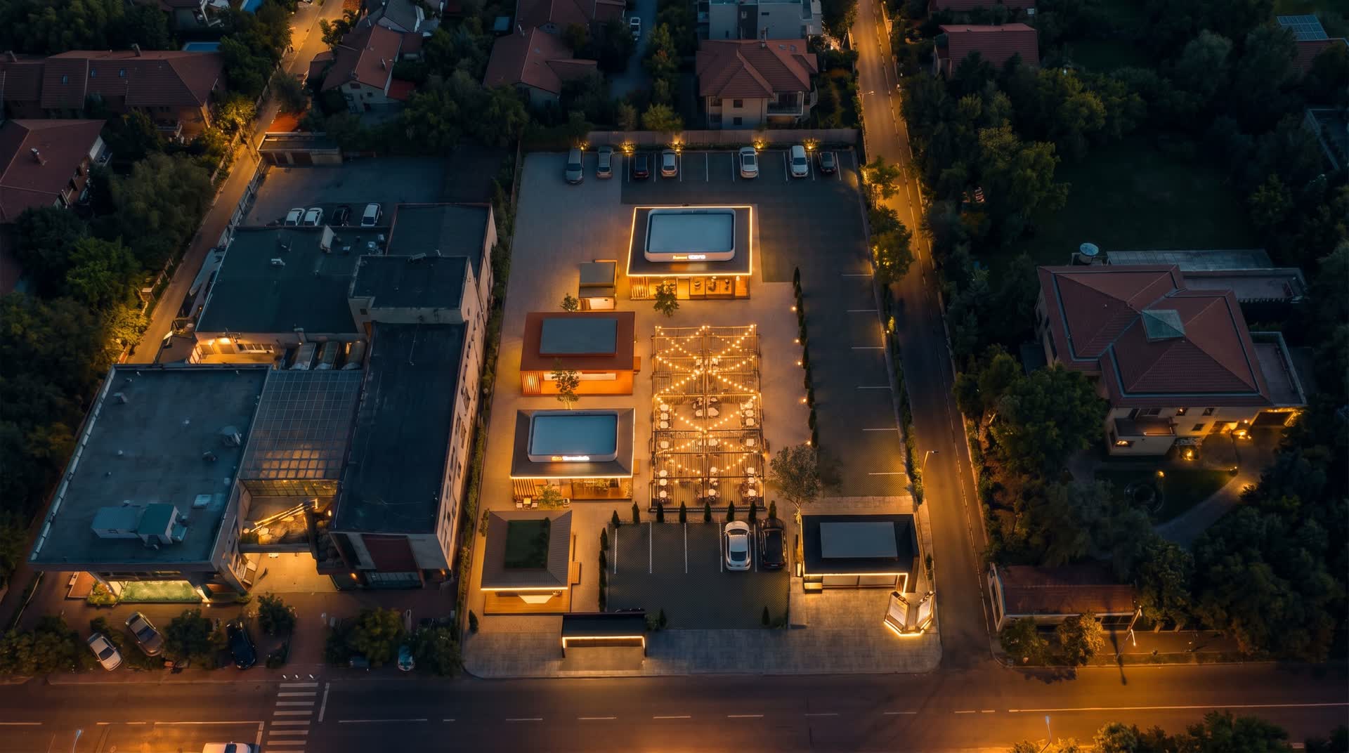 Vedere aeriană, noaptea, a unui complex cu chioșcuri modulare iluminate